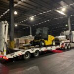 Truck transporting a forklift