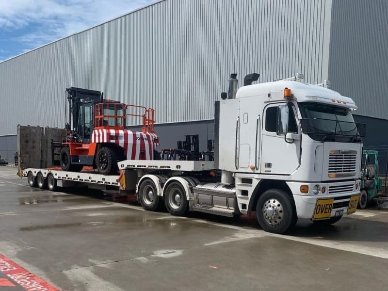 A prime mover loaded with Toyota forklifts representing the forklift transport available for Sydney and interstate customers