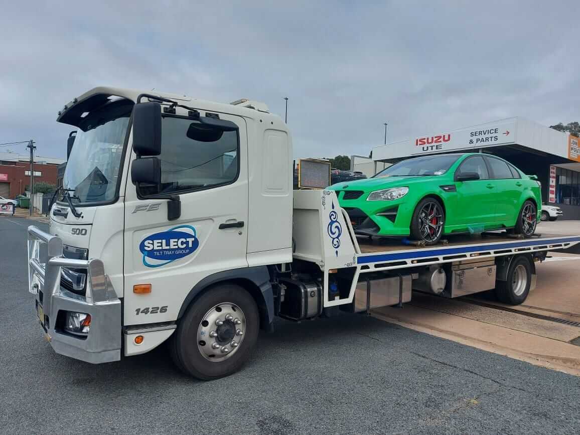 A Holden car being towed on the back of a tow truck.