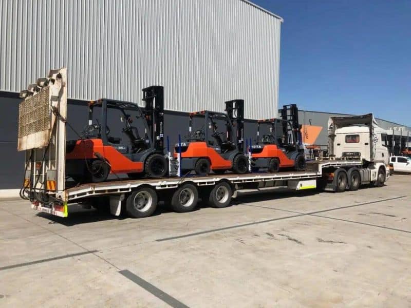 A prime mover loaded with forklifts representing the forklift transport available for Sydney and interstate customers