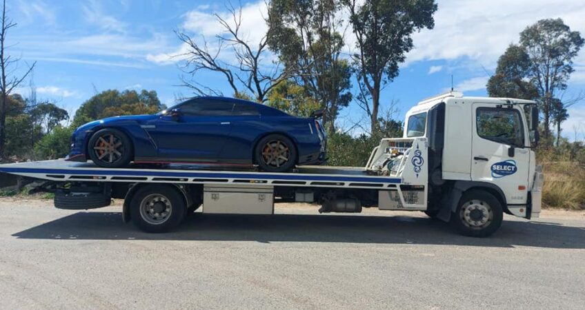 Nissan GTR R35 being towed on a flatbed tow truck
