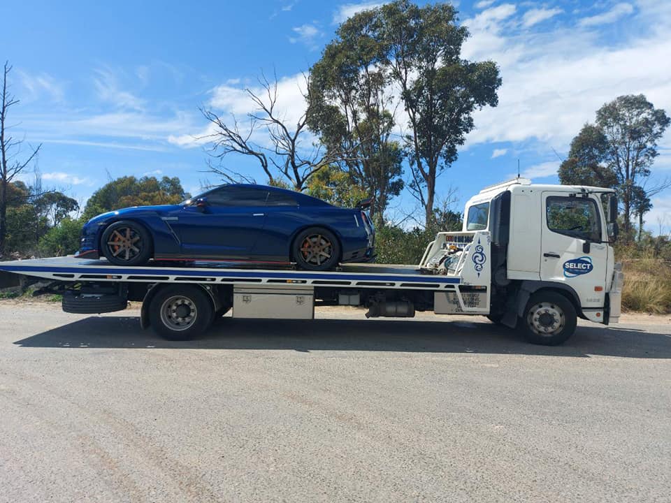 Nissan GTR R35 being towed on a flatbed tow truck