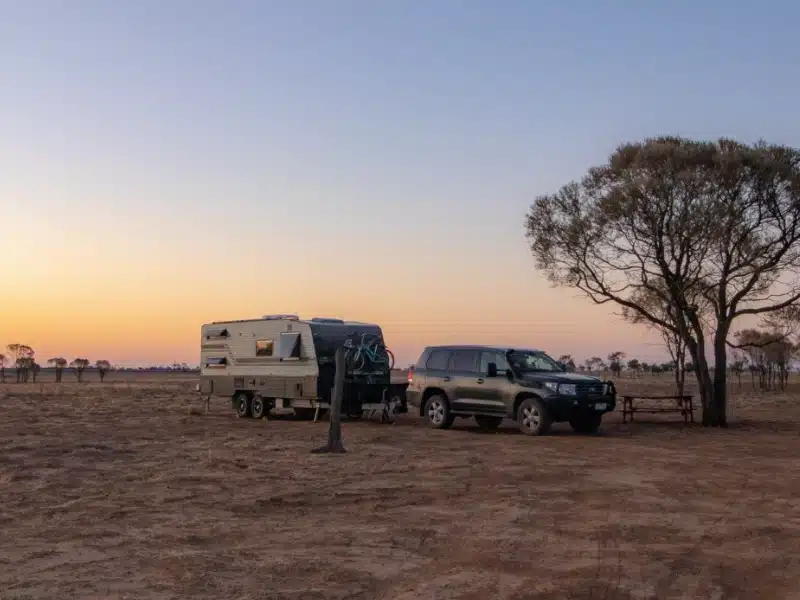 a photo of a 4 wheel drive towing a caravan in the outback
