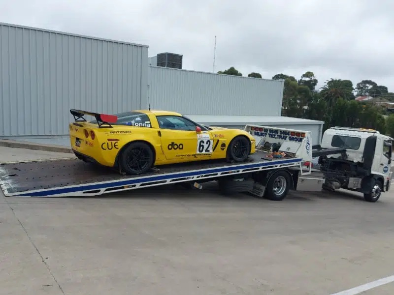 Corvette race car on the back of a tow truck